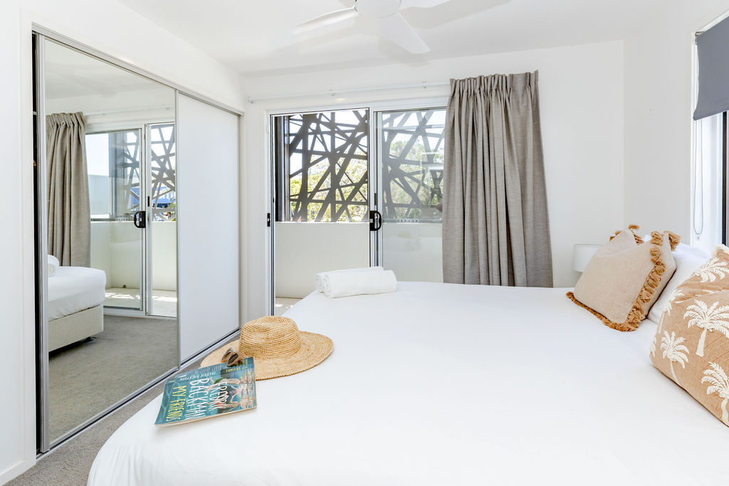 Master bedroom with plantation shutters and coastal styling