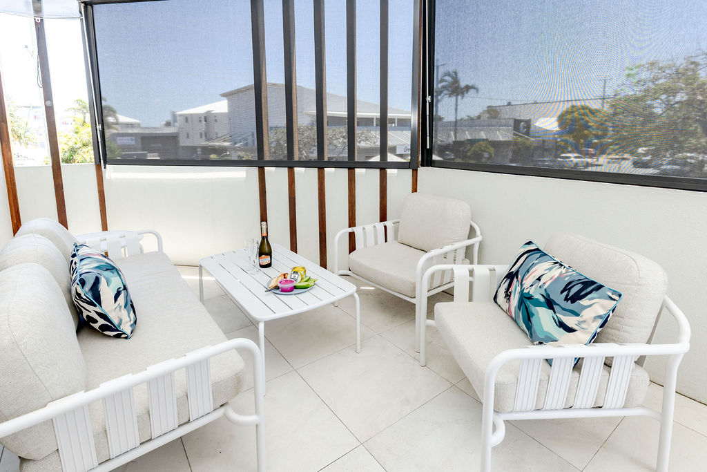 Private balcony with lounge seating and a welcome bottle